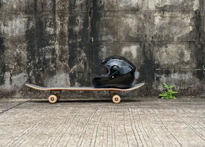 Side view of toy on skateboard against wall