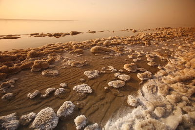 High angle view of salt crystals in sea during sunset