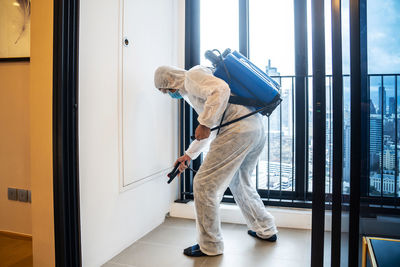 Man standing by window at home