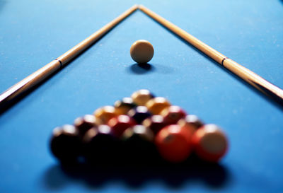 Close-up of pool balls and cues on table