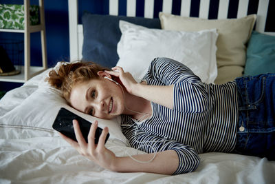 Woman lying down on bed at home