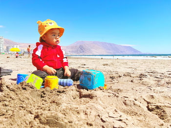 Rear view of boy sitting at beach