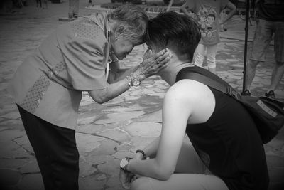 Grandmother embracing grandson on street