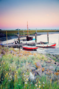 Boats moored on sea shore against sky