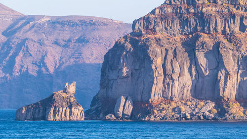 Rock formations by sea against sky