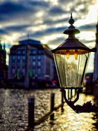 Close-up of illuminated lamp by street light