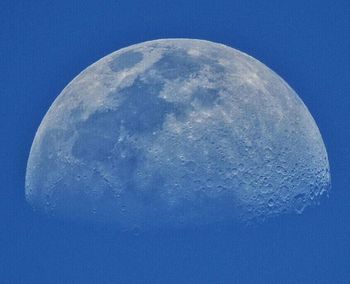 Low angle view of half moon against clear blue sky