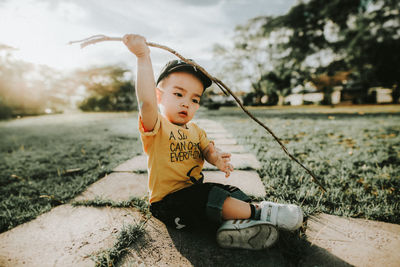 Cute boy playing on grass against sky