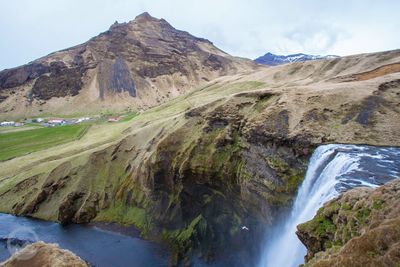 Scenic view of waterfall by mountain