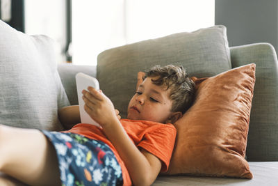 Midsection of woman relaxing on sofa at home