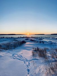 Scenic view of frozen lake against sky during sunset