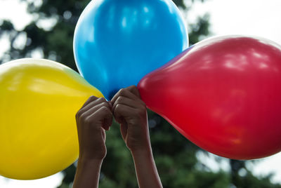 Close-up of multi colored balloons against blue sky