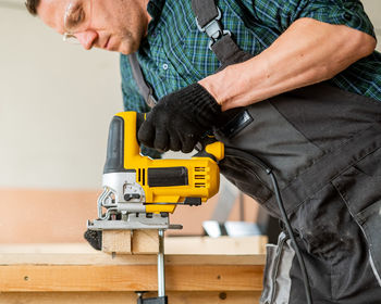 Midsection of man working at workshop