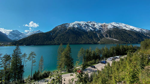 Scenic view of lake and mountains against clear blue sky