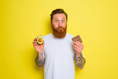 Portrait of man wearing mask against yellow background