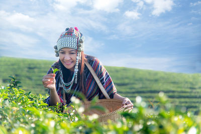 Smiling woman picking tea leaves