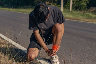 Rear view of man sitting on road