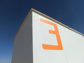 Low angle view of sign against clear blue sky