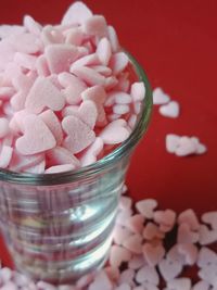 High angle view of heart shape candies in glass on table