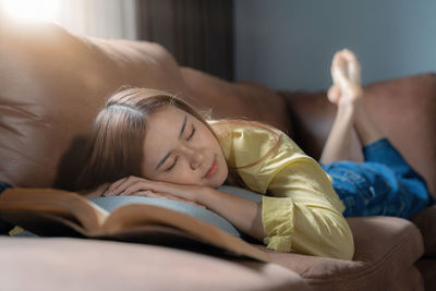 Portrait of young woman lying on bed at home