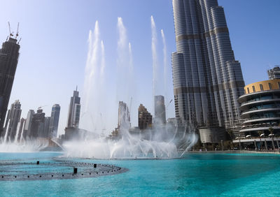 The dancing fountains downtown and in a man-made lake in dubai, uae in front of the burj khalifa