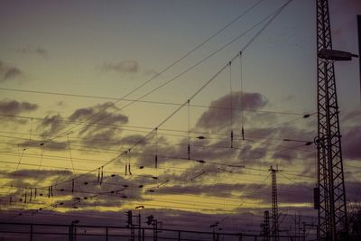 Electricity pylon against cloudy sky