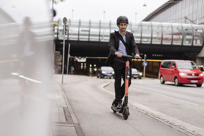 Businessman riding e-scooter in the city