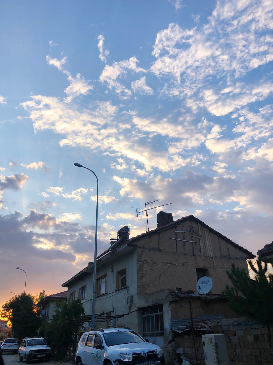 CARS ON STREET AMIDST BUILDINGS AGAINST SKY