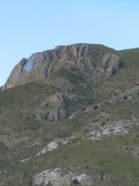 Low angle view of rocky mountains against clear sky