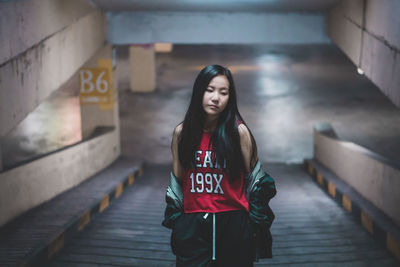 Beautiful young woman standing in parking lot