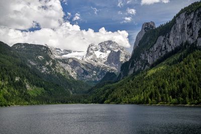 Scenic view of lake by dachstein mountains against sky