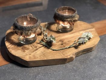 High angle view of burning candles on cutting board