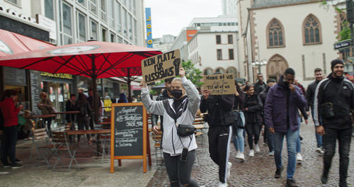 People walking on street amidst buildings in city