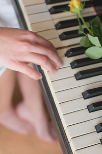 Close-up of hand playing piano