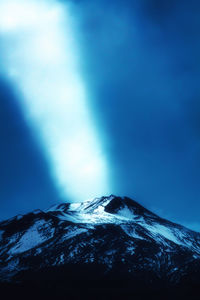 Scenic view of snowcapped mountains against blue sky