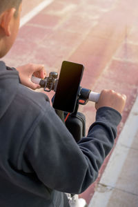 E-mobility, teenager using smart phone, on electric scooter, eco mobility concept