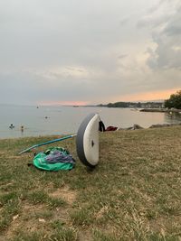 Deck chairs on shore at beach against sky