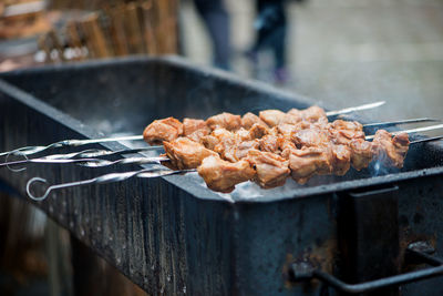 Close-up of meat in skewers on barbecue grill