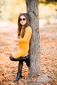 Cute stylish child girl 4-5 year old wear yellow knitted trendy dress and sun glasses  outdoor.