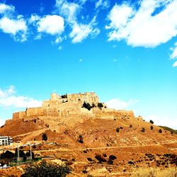 Low angle view of old ruin building against cloudy sky