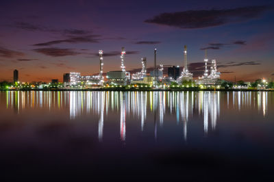 Illuminated factory against sky at night