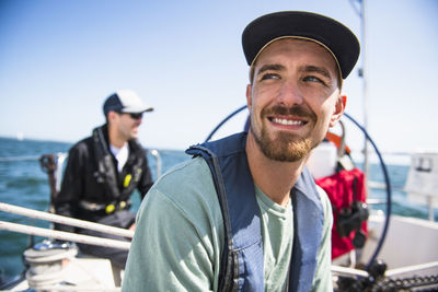 Man smiling during a family sail on sunny summer day