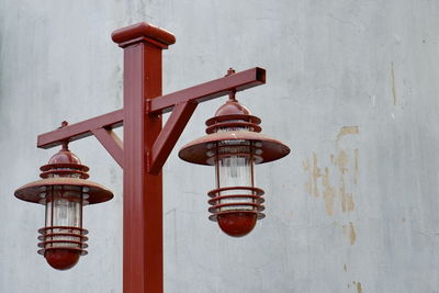 Low angle view of lantern on street light against wall