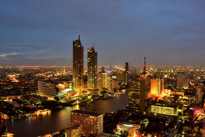 Illuminated cityscape against sky at night