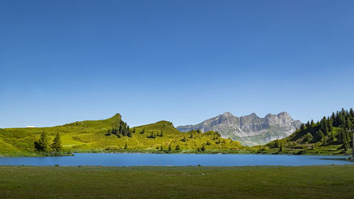 Scenic view of mountains against clear blue sky