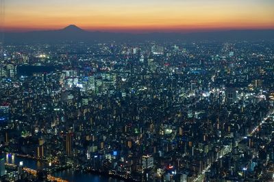 High angle view of illuminated city against sky at night