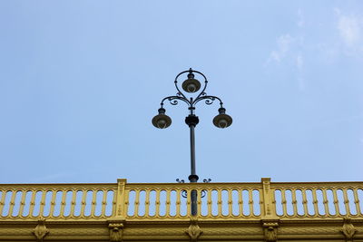 Low angle view of street light against blue sky