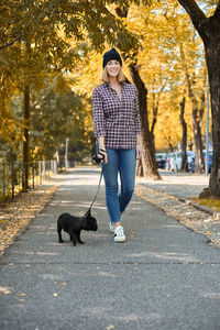 Full length of man with dog in park during autumn