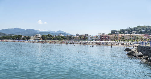 Scenic view of sea by city against clear sky