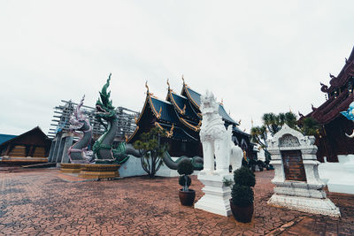 Statue against temple building against sky